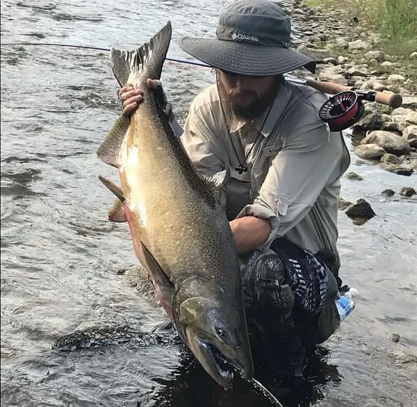 Head guide Cody with a large fall run salmon in Ontario